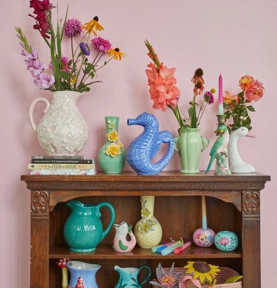 Bild av färgglada keramiska föremål på antik hylla