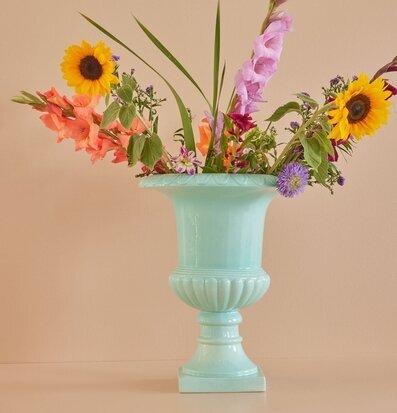 Foto av elegant pokalkruka med blommor i mintgrönt