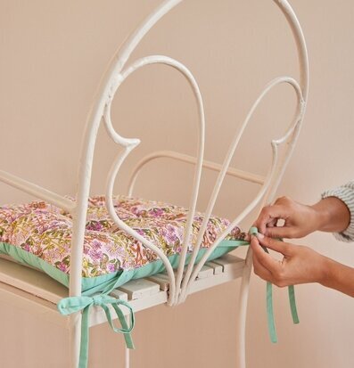 Bild av stolsdyna med blommönster och stilren design