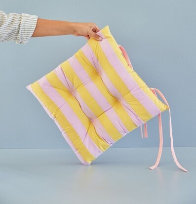 Foto av stolsdyna med randigt mönster i gult och lavendel