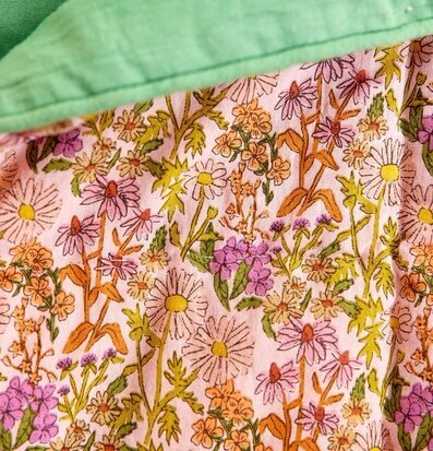 Bild av livfullt blommigt täcke med pastellrosa bakgrund