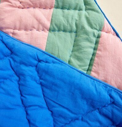 Bild av quilt i rosa och gröna ränder med blå kant