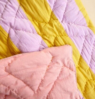 Bild av quilt i pastellfärger med geometriskt mönster