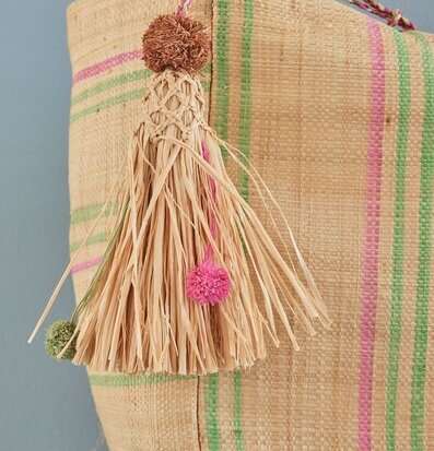 Bild av raffiaväska med randigt mönster och tofsar