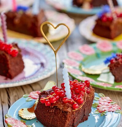 Bild av festligt dukat bord med chokladkaka och tomtebloss