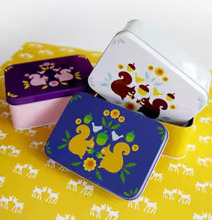 Bild av färgglada metallådor med ekorrar och blommor