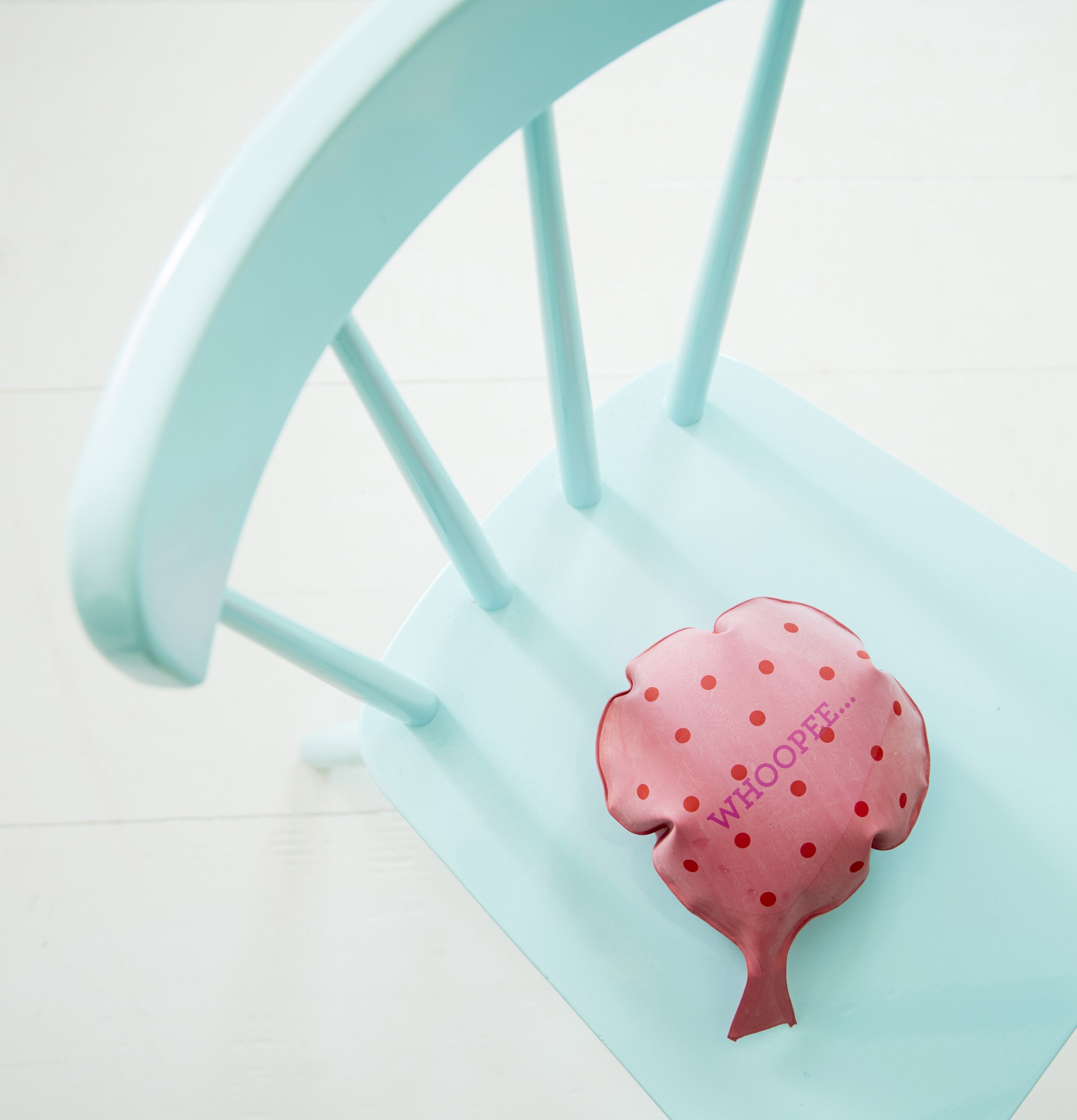 Foto av rosa pruttkudde på turkos stol i lantlig stil