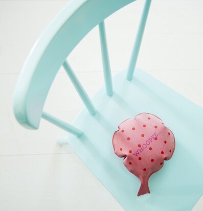 Foto av rosa pruttkudde på turkos stol i lantlig stil