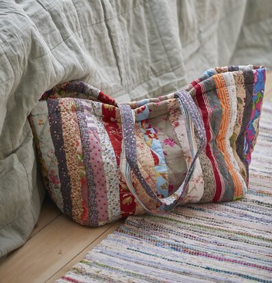 Foto av färgstark patchwork-väska mot grön bakgrund