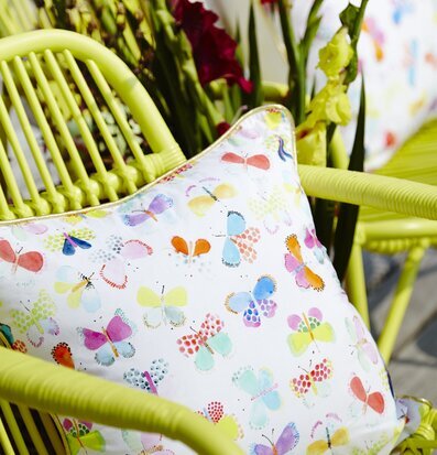 Bild av modern soffa med livfull kudde och blommor