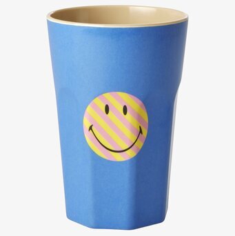 Foto av färgglad mugg med smiley och blå bakgrund