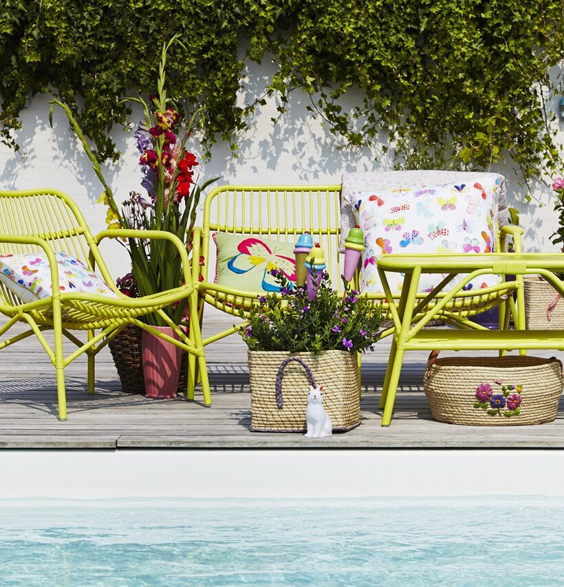 Cane 2 Seater Sofa Soft Yellow från Rice på en träterrass