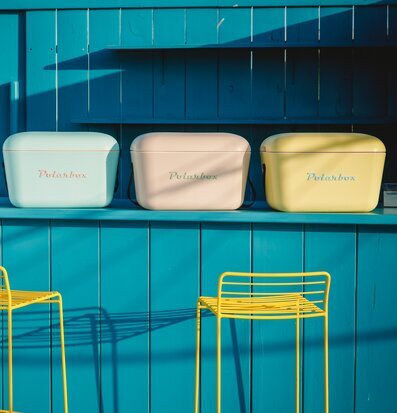 Bild av färgglada kylväskor i somrig strandmiljö