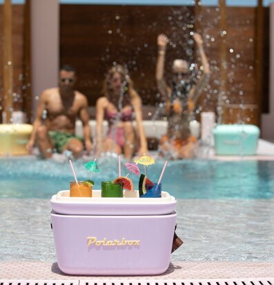 Bild av en livfull sommardag vid poolen med kylväska