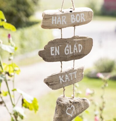 Bild av dekorativ skylt med glad katt- eller hundtext