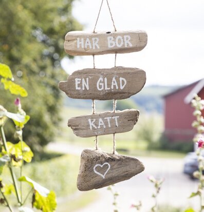 Bild av rustik skylt med texten Här Bor En Glad Katt