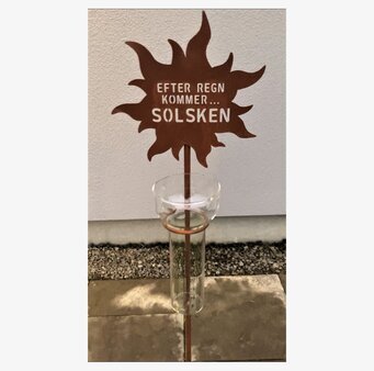 Foto av dekorativ och funktionell regnmätare i trädgård