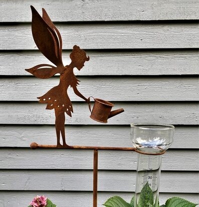 Foto av dekorativ regnmätare med älvmotiv i trädgård