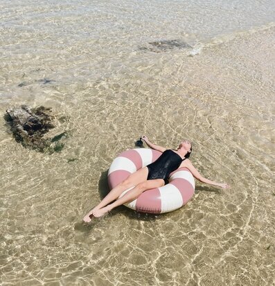 Bild avkopplande strandscen med badring i solnedgång