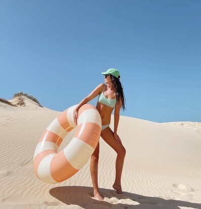 Foto av kvinna i öken med badring och sanddyner