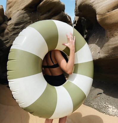 Foto av somrig stranddag med badring och klippor
