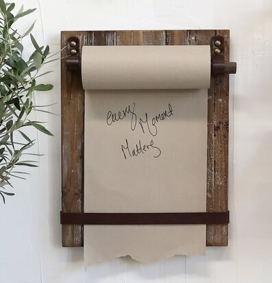 Bild av dekorativ pappersrulle på rustik träplatta