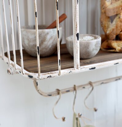 Bild av antik creme vägghylla med krokar och detaljer