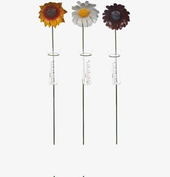 Foto av dekorativ regnmätare med blommor i trädgården