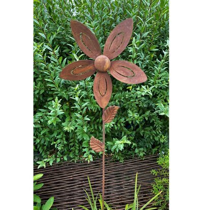 Bild av dekorativ vindsnurra i rostig trädgårdsmiljö