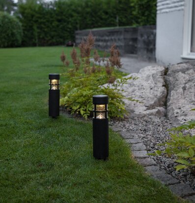 Bild av en lugn trädgård med solcellsbelysning