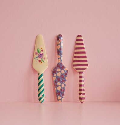 Bild av färgglada tårtspadar mot rosa bakgrund