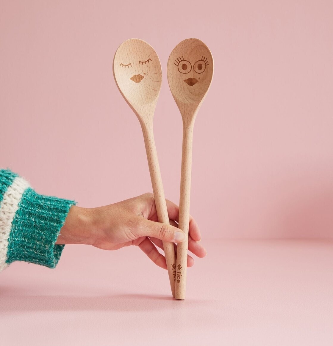 Träslev Smiling Face från Rice hålls av hand i stickad tröja