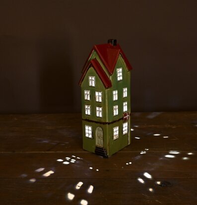 Bild av charmigt ljusgrönt solcellshus i skymning