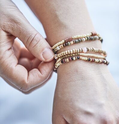 Foto av fem armband med naturliga och jordnära toner