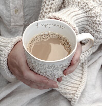 Bild av en vit mugg med kaffe och mysig atmosfär