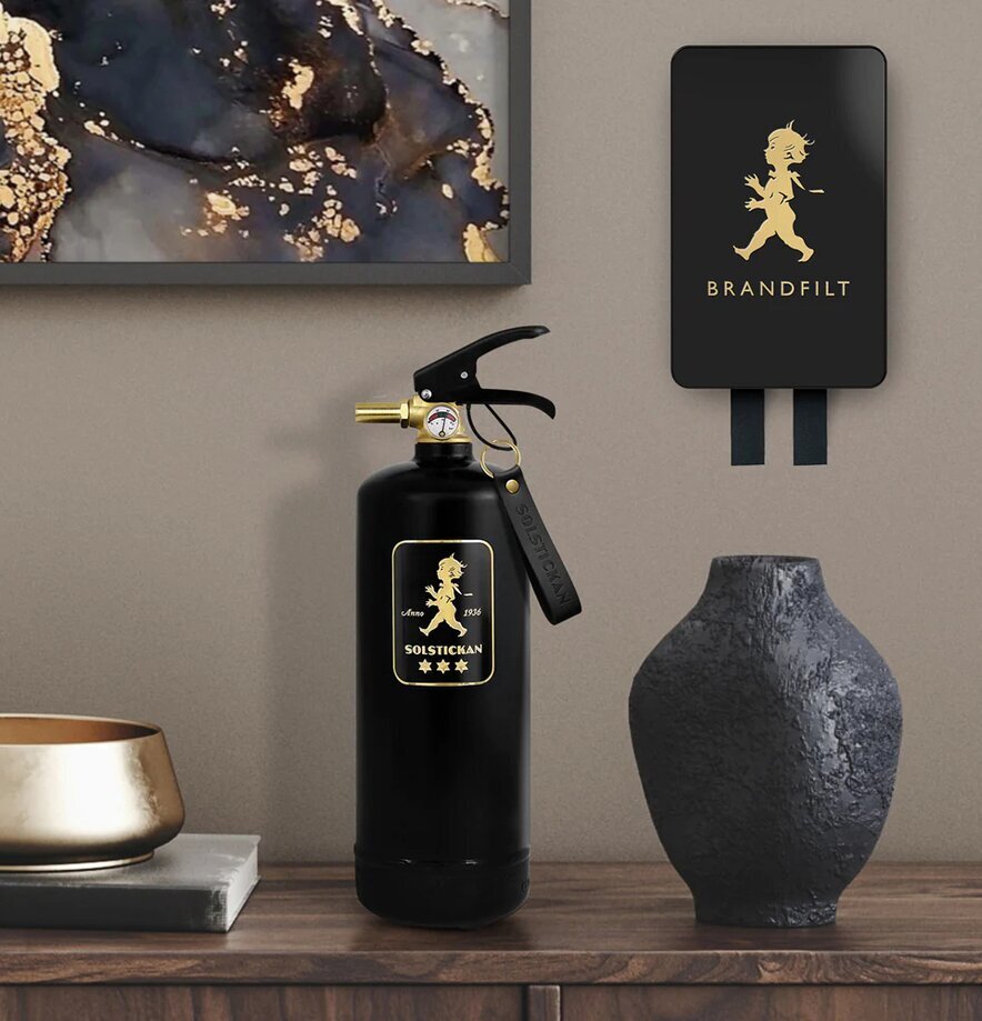 Brandfilt Svart/Guld Tablebook från Solstickan på vägg