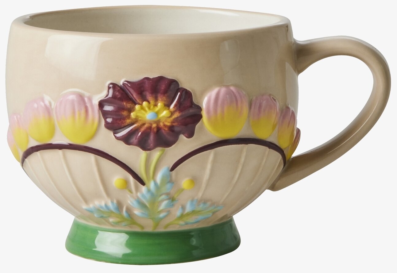 Bild av keramikmugg med blommönster och reliefdesign