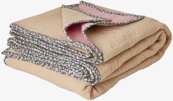 Bild av krusigt täcke med blommig kant och beige ton