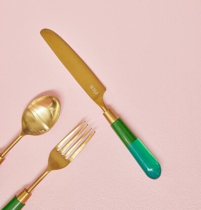 Foto av elegant mässingsbestick på rosa bakgrund