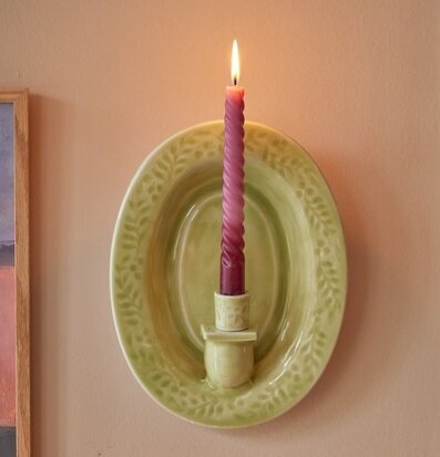 Bild av grön väggljusstake med rosa spiralformat ljus