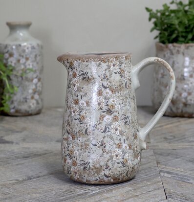 Foto av kanna med blommigt mönster och gröna nyanser