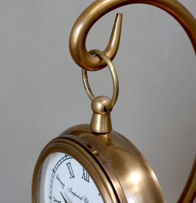 Bild av elegant klocka i mässing med klassisk design