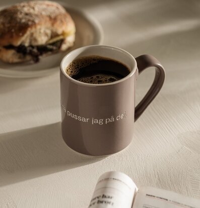 Bild av en lugn stund med mugg och kaffe i fokus