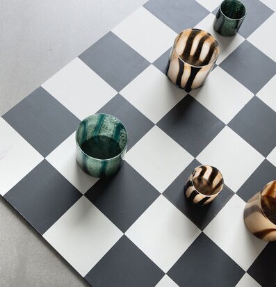 Bild av dekorativa ljuslyktor på schackrutigt golv