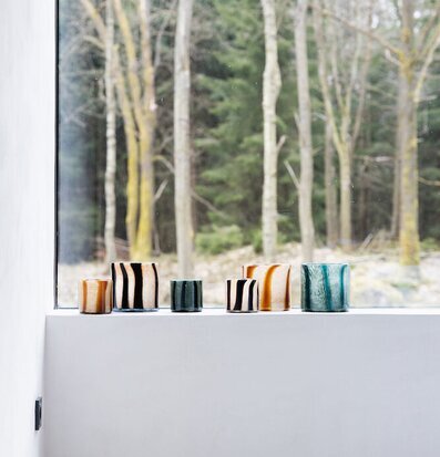 Bild av ljuslyktor i fönster med vinterlandskap