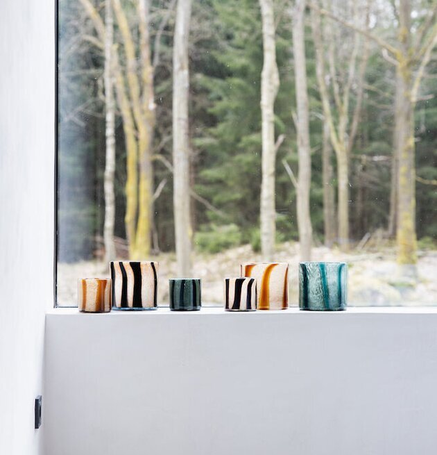 Bild av ljuslyktor i fönster med vinterlandskap