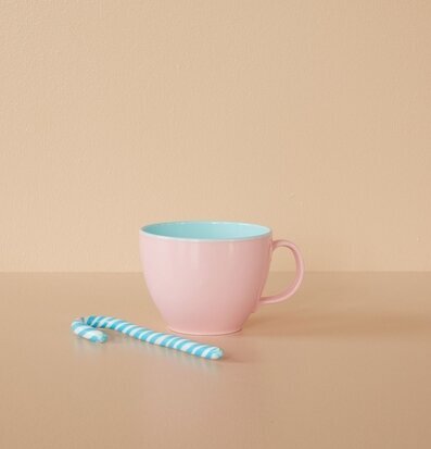 Bild av en färgglad mugg med pastelltoner och polkagris