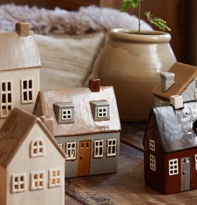 Bild av hemtrevlig scen med keramikhus och växt