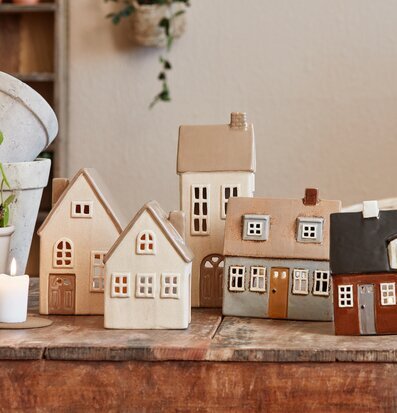 Bild av charmiga dekorativa keramikhus på rustikt bord