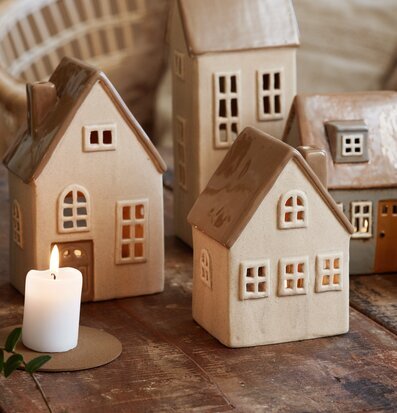 Bild av keramikljuslyktor som små hus i naturtoner